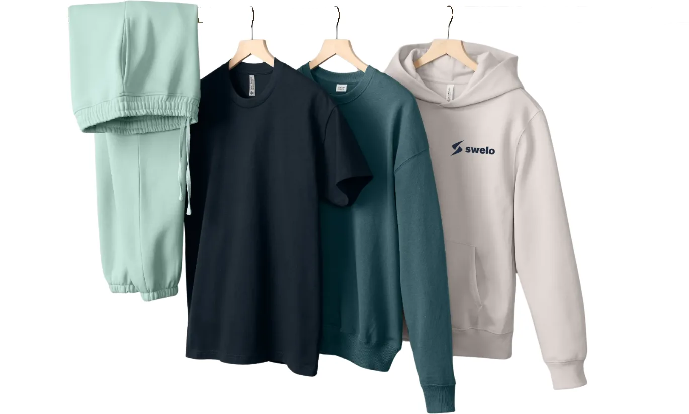 A rack of branded apparel — joggers, a tee, a crewneck, and a Swelo hoodie — the kind of program inventory an enterprise merch RFP asks a vendor to stock and manage.